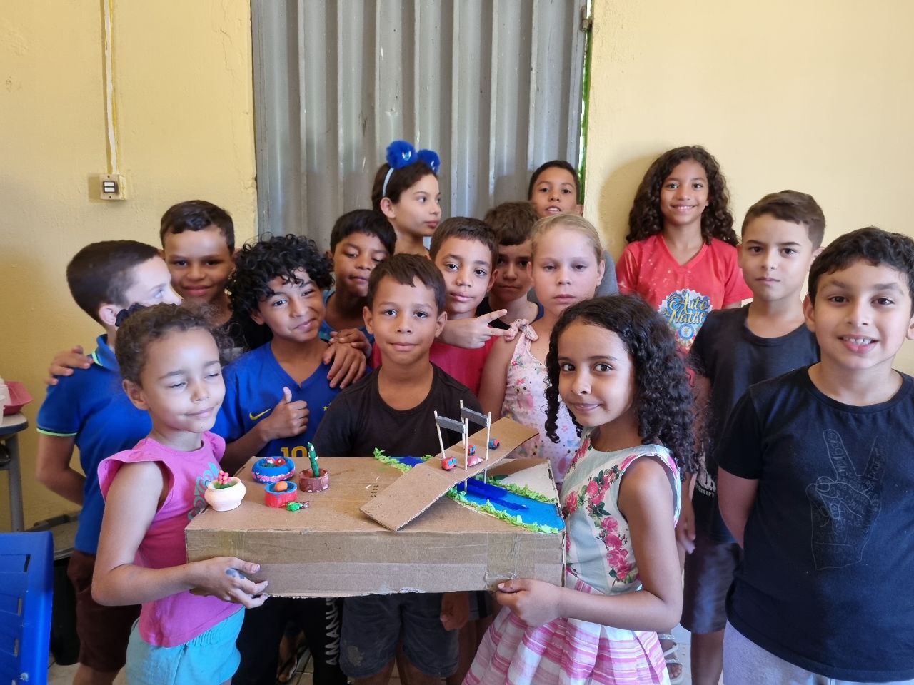 Crianças atendidas pelos projetos do Instituto Alicerce apresentando uma maquete